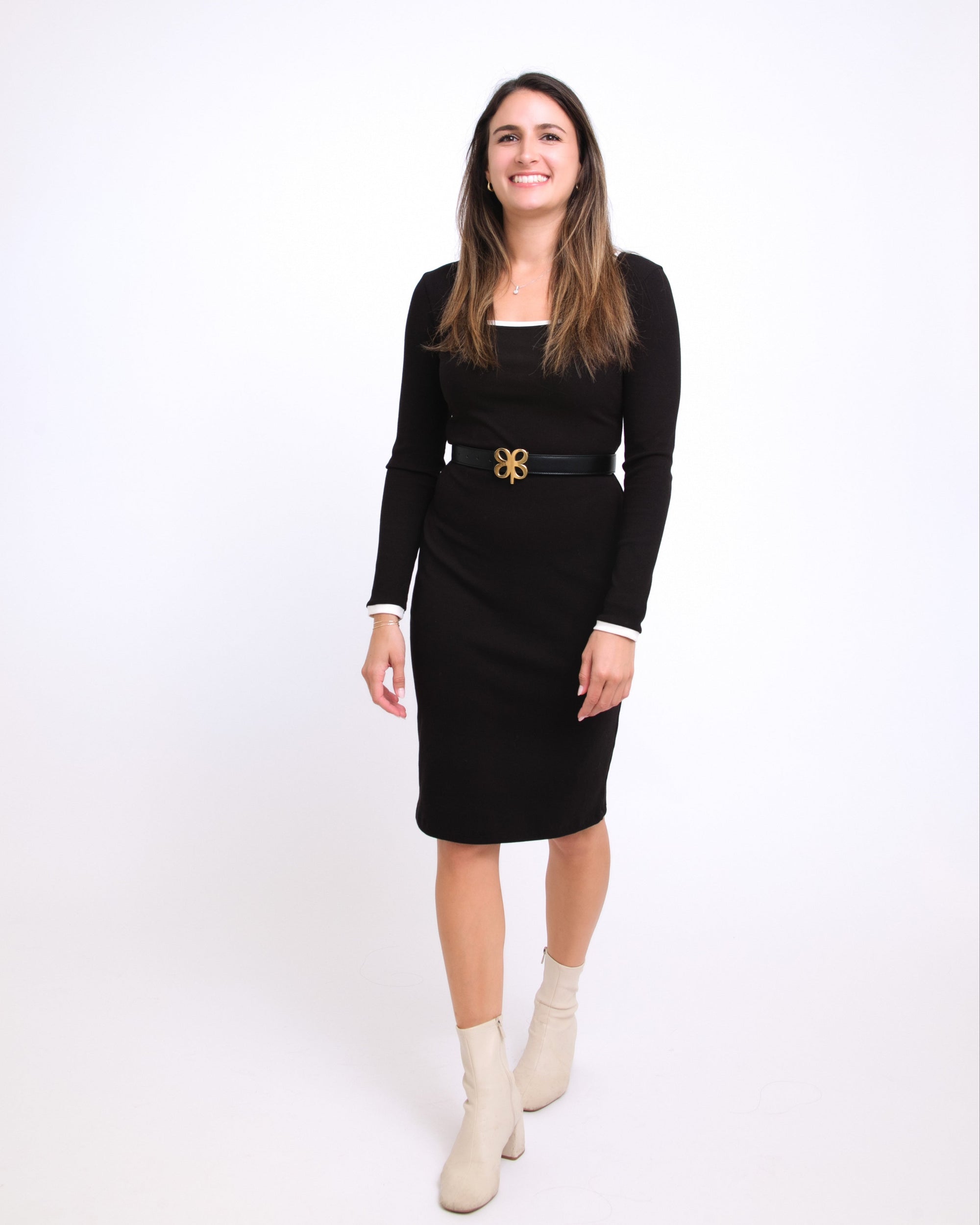 Woman wearing a black dress with a belt on a white background