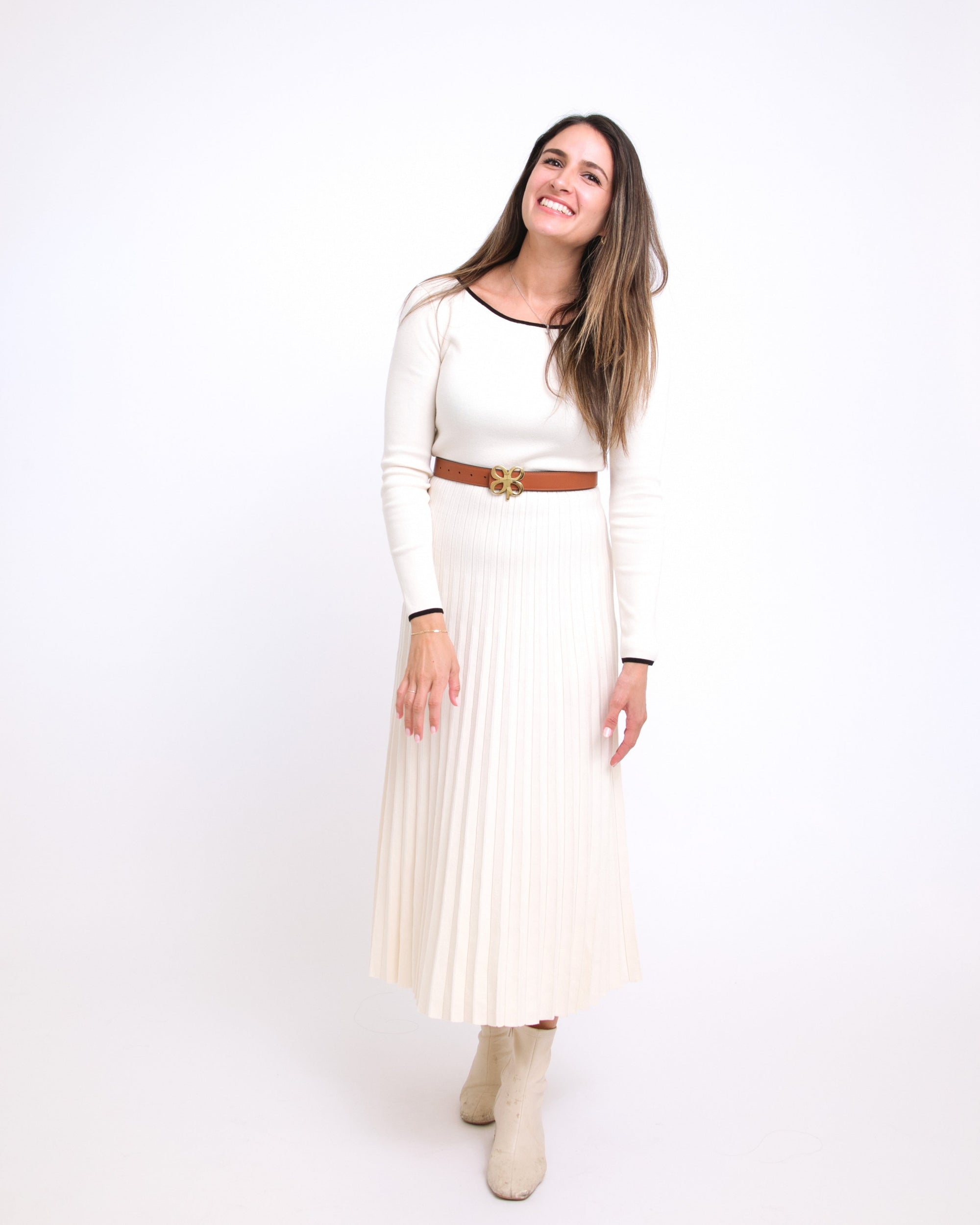 Woman wearing a white dress with a brown belt on a white background