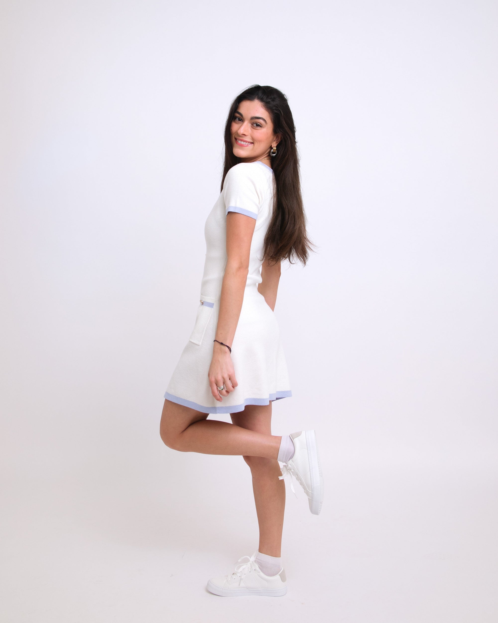 Woman wearing a white dress with a plain background